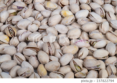Organic pistachios freshly harvested in shells, subtle soil dust and varied shell tones with visible green kernels, farm to table vibe for organic food marketing Organic pistachios freshly harvested in shells, subtle soil dust and varied shell tones with visible green kernels, farm to table vibe for organic food marketing 137822794
