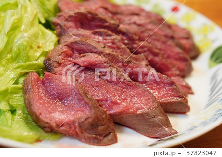 花柄の皿に盛られたローストビーフの断面がピンク色に輝くごちそう料理写真 137823047