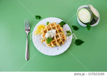 homemade zucchini waffles with creamy topping and parsley garnish 137823200