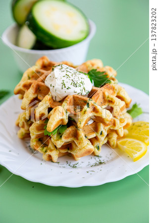 healthy zucchini waffles with sour cream and fresh parsley garnish 137823202