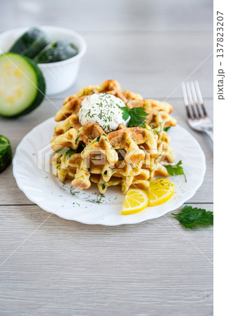 homemade zucchini waffles with creamy topping and lemon garnish homemade zucchini waffles with creamy topping and lemon garnish 137823207
