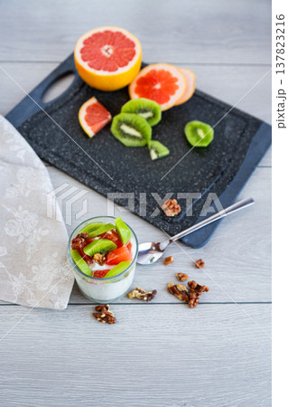 fresh yogurt dessert with fruits and nuts on wooden table fresh yogurt dessert with fruits and nuts on wooden table 137823216