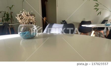 a vase on the left on the table 137823557