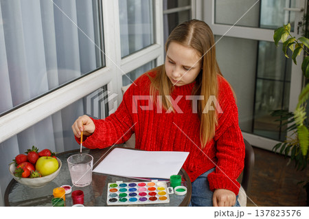 Concentrated child drawing pink cats in a sketchbook. Young preteen girl painting Concentrated child drawing pink cats in a sketchbook. Young preteen girl painting 137823576