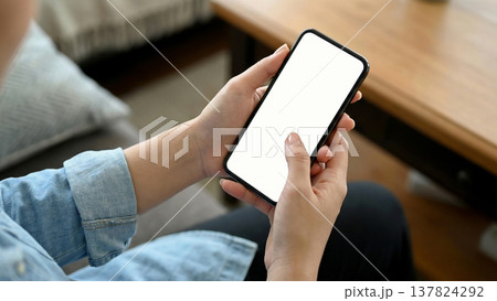 白い画面のスマートフォンを操作する女性の手元のモックアップ素材 白い画面のスマートフォンを操作する女性の手元のモックアップ素材 137824292
