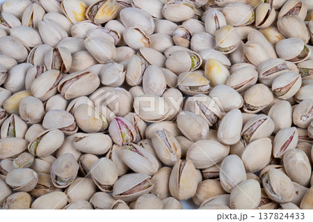 Close up pistachios in shells, rustic market pile showcasing beige shells and green kernels, coarse texture, soft daylight, natural food styling for packaging and grocery displays Close up pistachios in shells, rustic market pile showcasing beige shells and green kernels, coarse texture, soft daylight, natural food styling for packaging and grocery displays 137824433