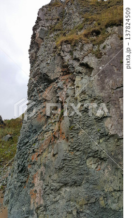 A mesmerizing view of cliffs along the sandy beach of the Kuril Islands. A mesmerizing view of cliffs along the sandy beach of the Kuril Islands. 137824509