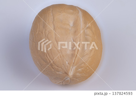 Closeup of textured walnut shell. Studio lighting highlights walnut shell seam and texture. Detailed visual examination capturing seam and surface texture of walnut in shell Closeup of textured walnut shell. Studio lighting highlights walnut shell seam and texture. Detailed visual examination capturing seam and surface texture of walnut in shell 137824593
