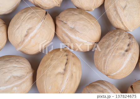 Baking walnuts in shells ready for cracking, warm tones suggest artisan baker preparing ingredients for pastry and dessert, tactile shells and scattered dust visible Baking walnuts in shells ready for cracking, warm tones suggest artisan baker preparing ingredients for pastry and dessert, tactile shells and scattered dust visible 137824675