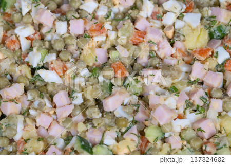 Stylish salad display. Contemporary flat arrangement highlighting Olivier salad details. Elegant topdown view presenting Olivier salad garnished with herbs on linen background 137824682