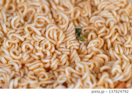 Steaming instant noodles in seasoned broth with scallion fleck, close framing conveys warmth and savory aroma, cozy meal vibe for comfort food and latenight snack concepts 137824792
