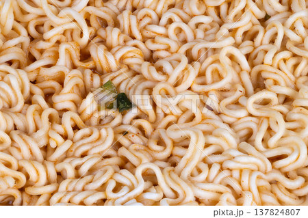 Closeup styled instant noodles with tiny herb focal point, glossy strands and rich seasoning suggest editorial food photography setup and social media trendy food shot 137824807
