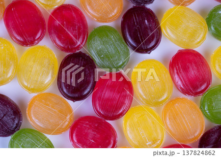 Bright multicolored sweets with reflections. Vivid multihued confectionery displaying shine and texture. Dramatic macro shot of colorful candies highlighting sugar and shine 137824862