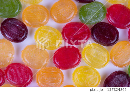 Colorful variety of glossy confections displayed on simple background image. An energetic portrayal of vibrant assortment of shiny candies captured in closeup for vivid detail Colorful variety of glossy confections displayed on simple background image. An energetic portrayal of vibrant assortment of shiny candies captured in closeup for vivid detail 137824863