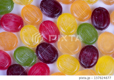 Multicolored candies form rhythmic pattern under macro lens, repeating circular shapes create graphic texture and symmetry, suitable for abstract backgrounds and modern design Multicolored candies form rhythmic pattern under macro lens, repeating circular shapes create graphic texture and symmetry, suitable for abstract backgrounds and modern design 137824877