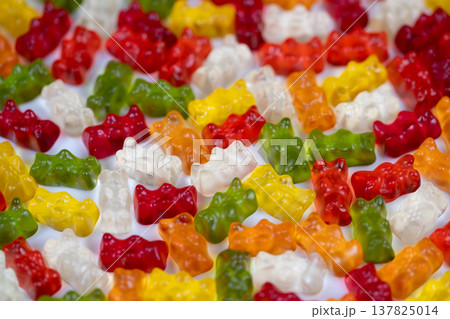 Scattered multicolored gummy bears evoking party energy, high saturation and shallow depth emphasize candy shapes, ideal for celebration, confectionery and holiday visuals Scattered multicolored gummy bears evoking party energy, high saturation and shallow depth emphasize candy shapes, ideal for celebration, confectionery and holiday visuals 137825014