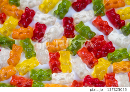 Colorful candy display. Vibrant gummy bears with shine. Brightly colored gummies stacked for presentation. Multicolored gummy bears arranged to showcase sparkle and texture 137825036