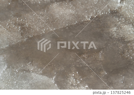 Ice softly dissolves. Gentle water reveals frozen levels. Frozen sheets gradually dissolve under flowing streams. Graceful melting exposes layers of ice in quiet streams 137825246