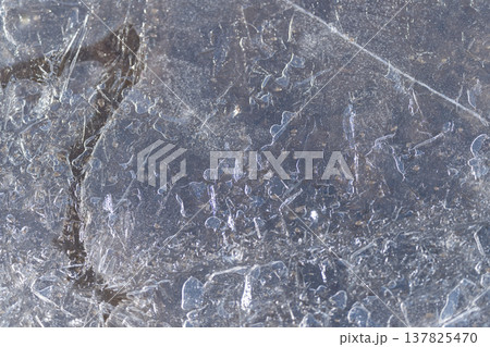 Polished thawed ice displays subtle shimmer and scratches. Smoothly thawed ice plane exhibits faint scratches along with soft reflective glow across its surface 137825470