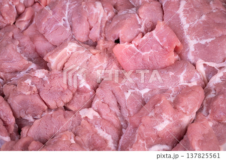 Fresh pork slices. Uncooked pork pieces on stainless platform ready for culinary process. Raw pork slices stacked neatly on stainless surface awaiting preparation and cooking Fresh pork slices. Uncooked pork pieces on stainless platform ready for culinary process. Raw pork slices stacked neatly on stainless surface awaiting preparation and cooking 137825561