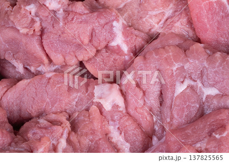 Butcher display fresh meat arranged on tray, multiple pork cuts with visible marbling and fat seams, refrigerated setting suggests cleanliness and retail readiness for consumers Butcher display fresh meat arranged on tray, multiple pork cuts with visible marbling and fat seams, refrigerated setting suggests cleanliness and retail readiness for consumers 137825565
