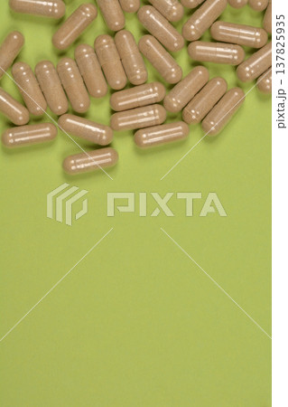 Brown capsules on green background with copy space 137825935