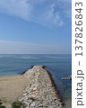 砂浜と穏やかな海に伸びる石造り防波堤縦位置 137826843