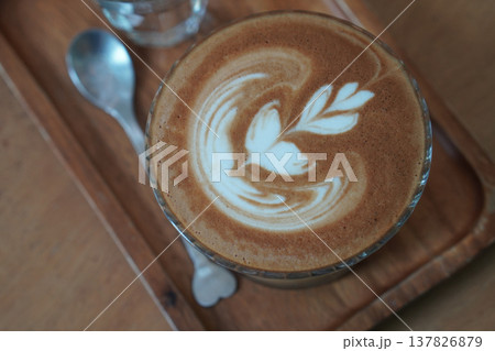 top view brown coffee in low glass on wooden tray, silver spoon and water in glass, brown wooden floor background, drink, cool, food, copy space 137826879