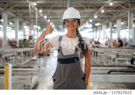 Professional occupation, standing. Woman is in the window making factory Professional occupation, standing. Woman is in the window making factory 137827023