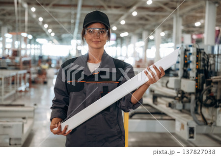 Professional uniform. Woman is in the window making factory 137827038