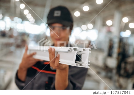 The part of frame in hands, plank. Woman is in the window making factory The part of frame in hands, plank. Woman is in the window making factory 137827042