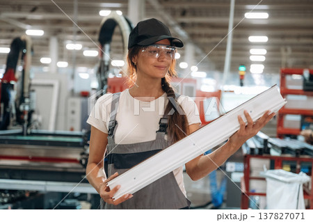 Plank in hands, standing. Woman is in the window making factory Plank in hands, standing. Woman is in the window making factory 137827071