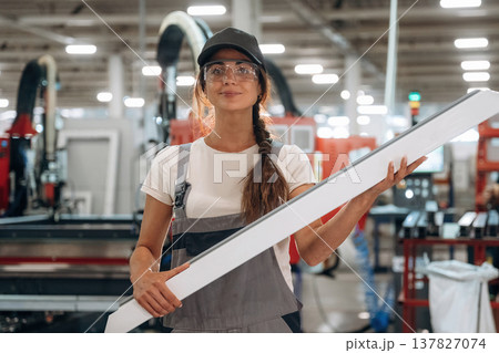 Plank in hands, standing. Woman is in the window making factory 137827074
