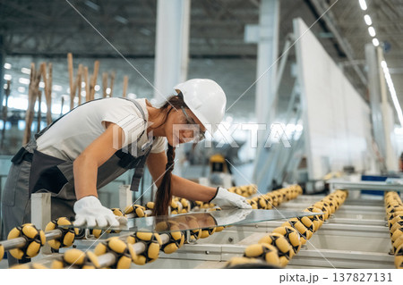 Pieces of new glass, on the production line. Woman is in the window making factory 137827131