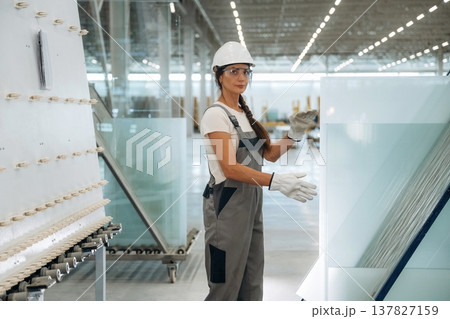 Employee is on the job. Woman is in the window making factory Employee is on the job. Woman is in the window making factory 137827159