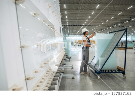 Moving bunch of glass. Woman is in the window making factory Moving bunch of glass. Woman is in the window making factory 137827162