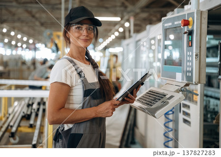 Machinery computer operator. Woman is in the window making factory 137827283