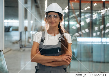 Arms crossed, standing and posing. Woman is in the window making factory 137827311