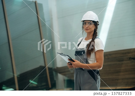 Manufacturing conception, standing. Woman is in the window making factory 137827333