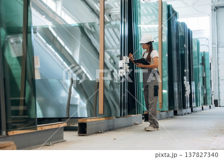 Bunch of glass. Woman is in the window making factory Bunch of glass. Woman is in the window making factory 137827340