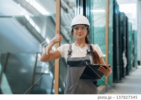 Job well done, thumb up. Woman is in the window making factory Job well done, thumb up. Woman is in the window making factory 137827345