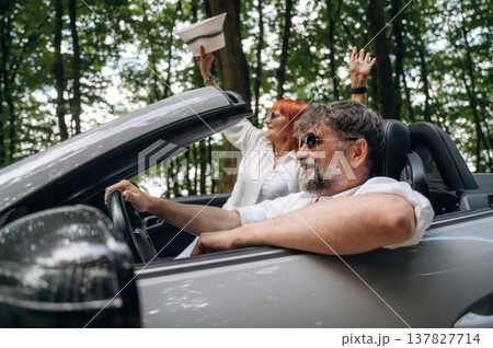 Hands are up, happy woman is with hat. Senior couple driving convertible cabriolet car 137827714