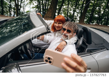 Senior couple driving convertible cabriolet car Senior couple driving convertible cabriolet car 137827763