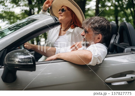 Comfortable vehicle, vacation conception. Senior couple driving convertible cabriolet car 137827775