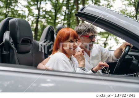 View from the side. Senior couple driving convertible cabriolet car 137827843
