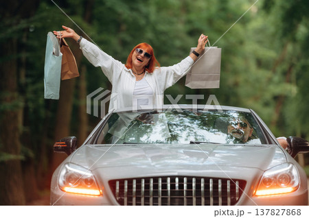After the shopping, with bags. Senior couple driving convertible cabriolet car After the shopping, with bags. Senior couple driving convertible cabriolet car 137827868