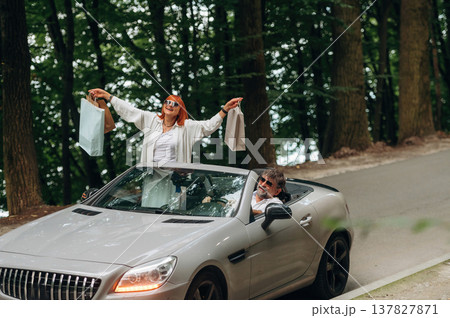 Shopping bags are in hands. Senior couple driving convertible cabriolet car 137827871