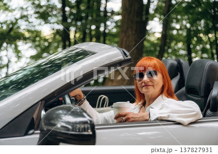 Side view of woman that is driving convertible cabriolet car Side view of woman that is driving convertible cabriolet car 137827931