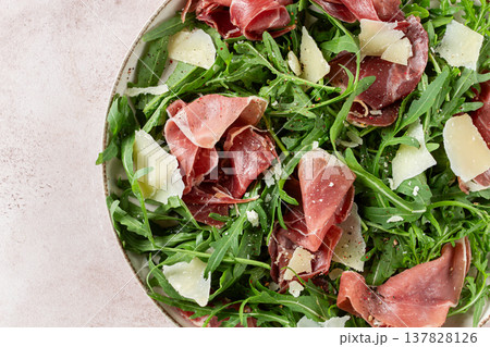 Fresh arugula salad with prosciutto and grated parmesan cheese, on a plate, homemade, no people, 137828126