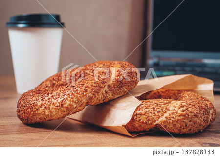 simits with coffee on a wooden table, with a laptop, in a cozy working environment, snack, breakfast, no people, 137828133